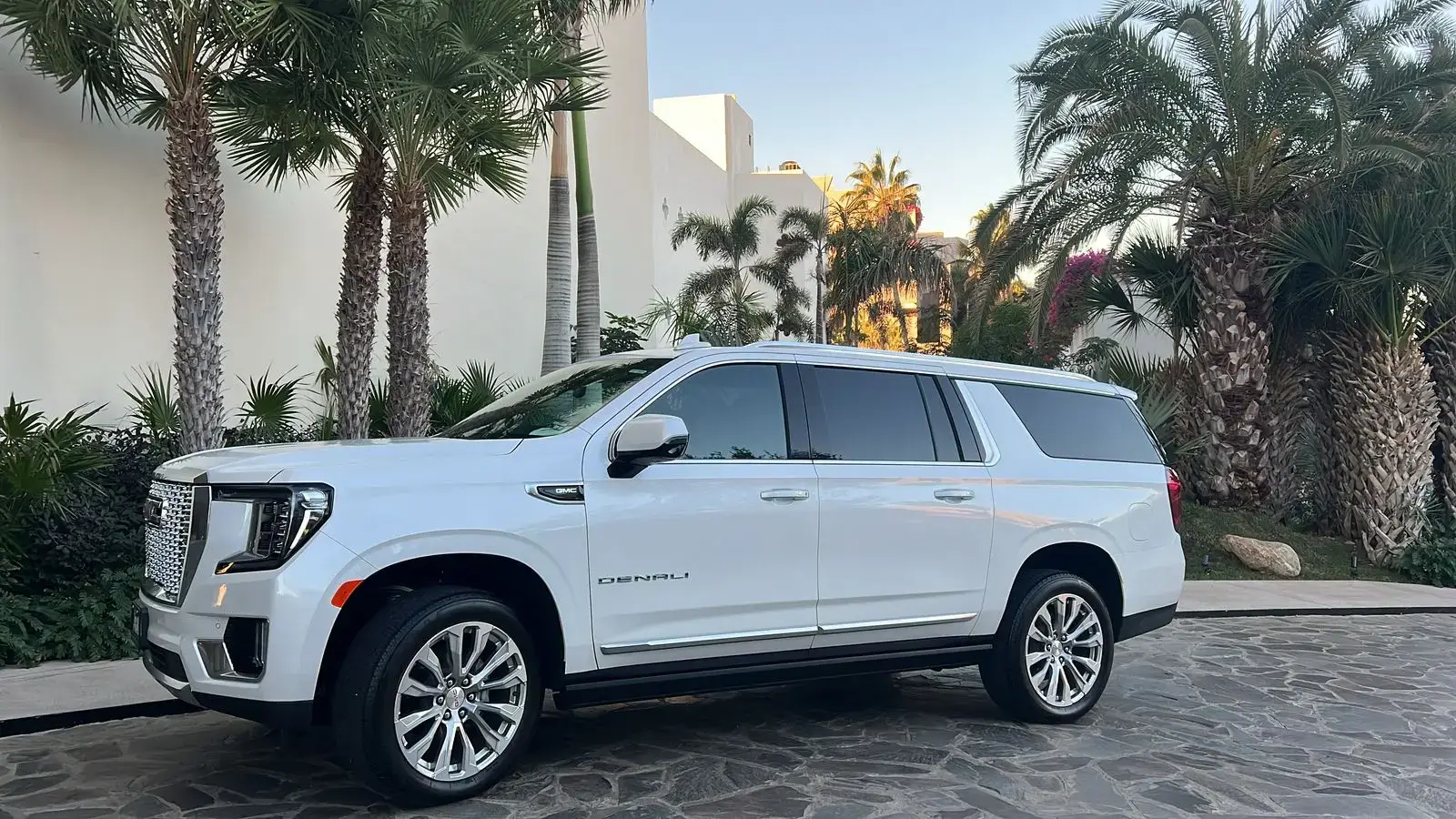 White Private luxury SUV transportation for up to 6 passengers provided by Los Cabos Airport Transportation at a lobby hotel